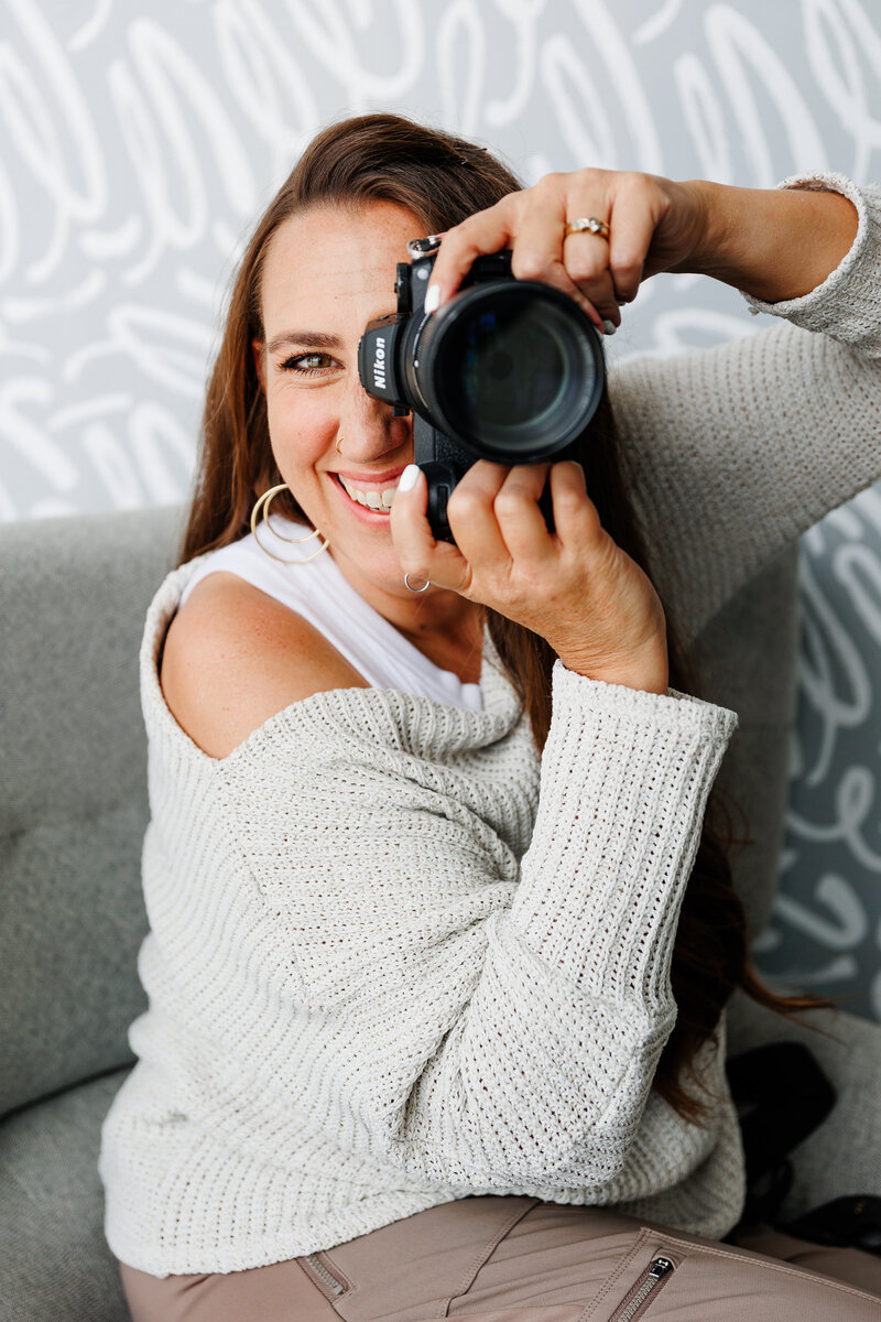 branded photography with denver commercial photographers for denver branding photos with camera up to her face.