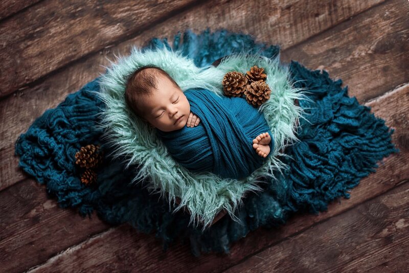 In-home Vancouver newborn photos with 17 day old baby boy in teal wrapped in wooden heart