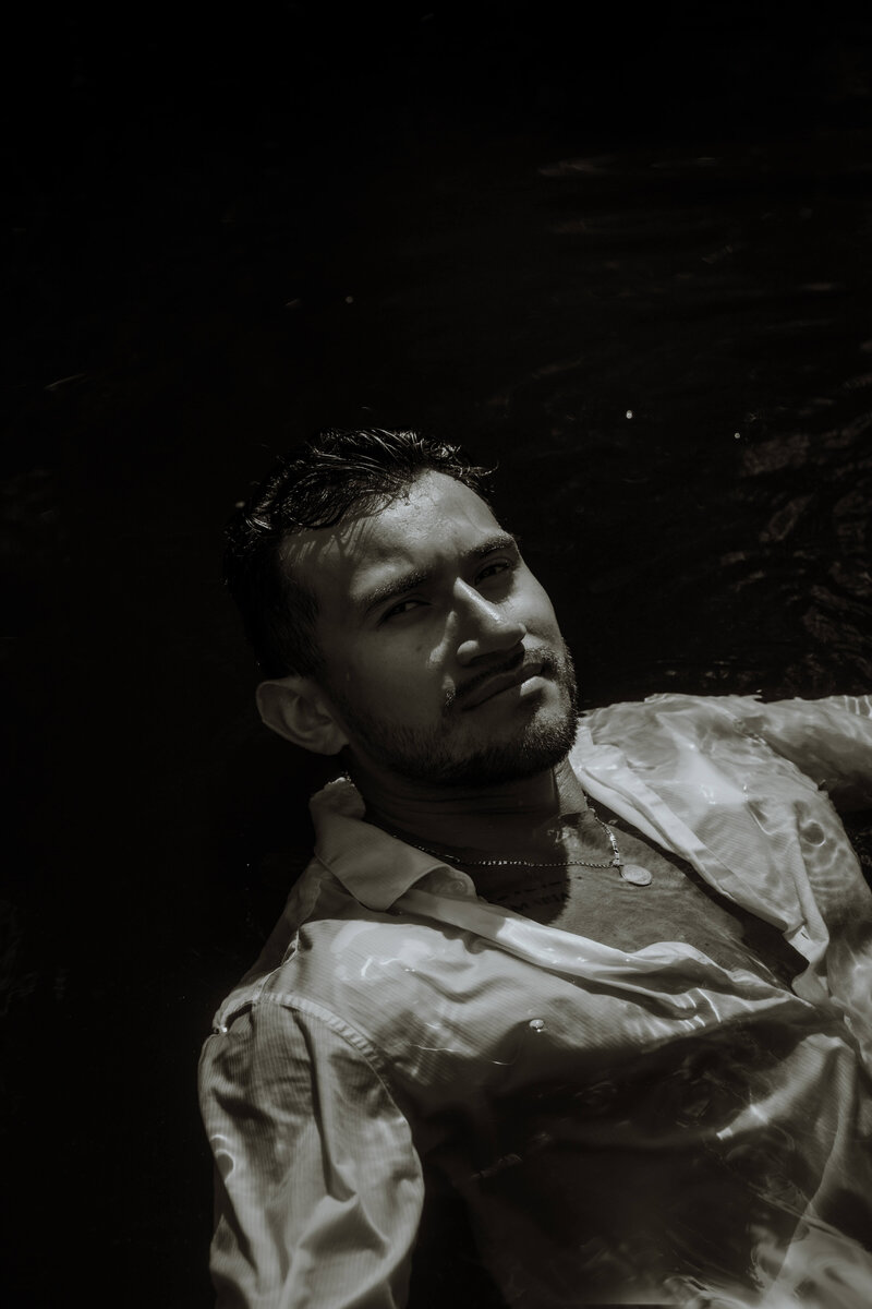 black and white photo of man coming out of water