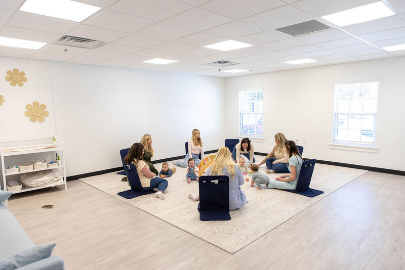 Group of women sitting on the floor while their babies play