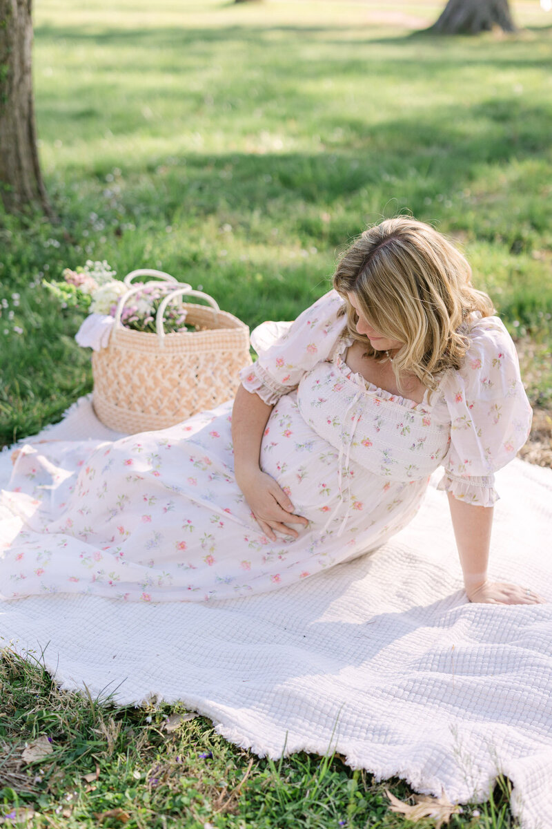 Family standing in a green park and playing during their maternity photos with missy marshall