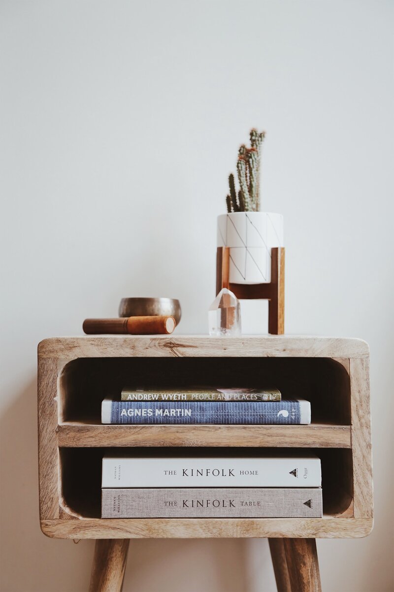 accent table with books, a plant, and other decor