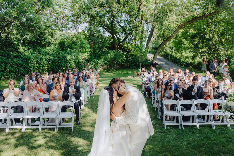 Bride and groom kissing at outdoor wedding ceremony in Finger Lakes New York