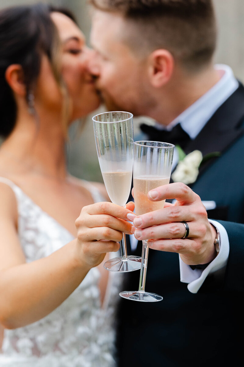 Ottawa wedding photography showing  a bride and groom clinking glasses with champagne
