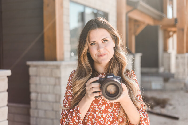 woman smiling and holding a camera