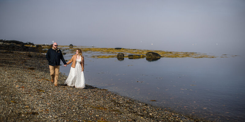 Wedding couple exploring Maine’s rugged coastline, creating a picturesque destination wedding memory.