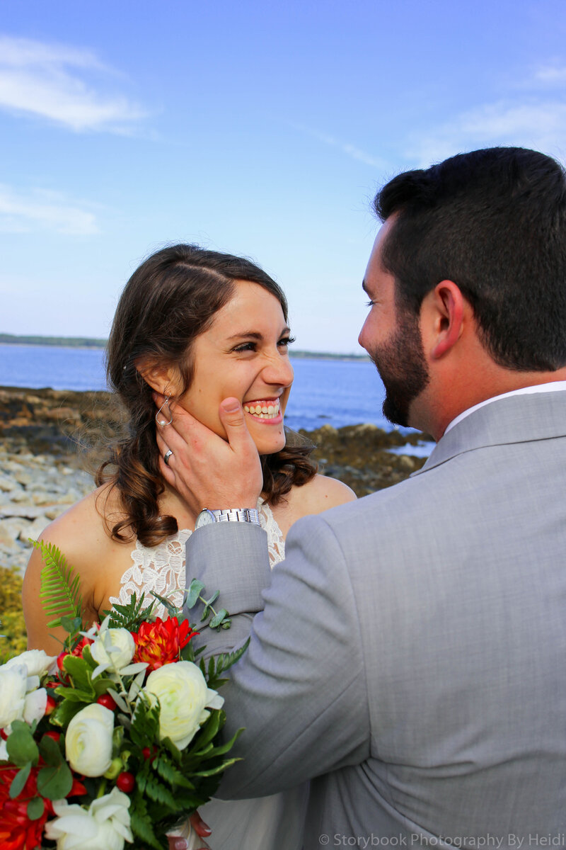 Groom holding bride's face on beach | Acadia Wedding