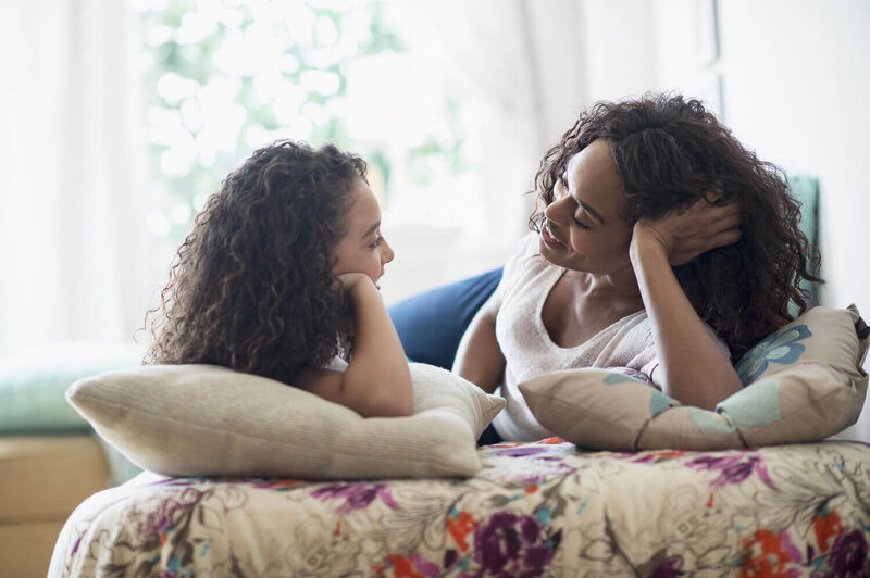 Mother and daughter talking on the couch