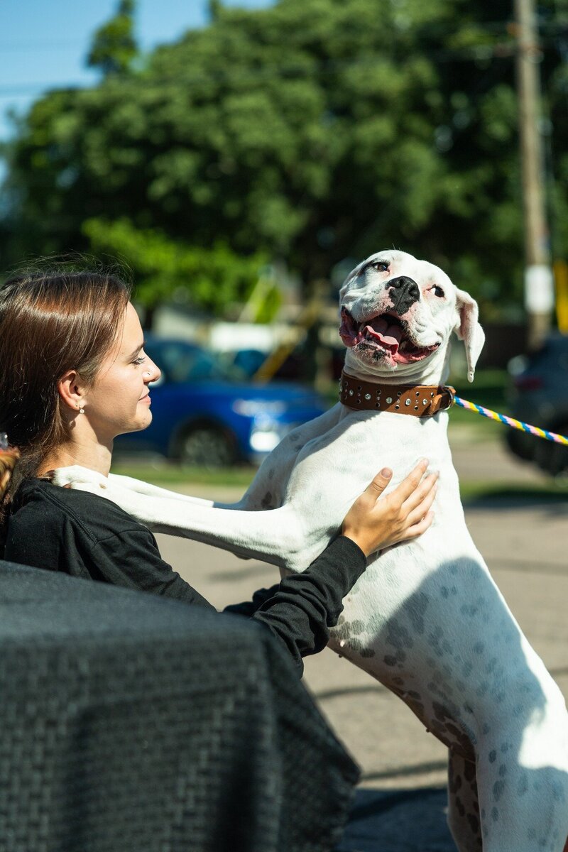Roxi & Co team member smiling with a happy dog, representing the joy of working with pets and people at Roxi & Co careers.