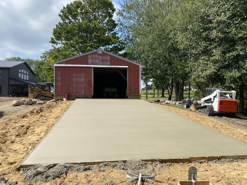 New concrete pad in front of a red pole barn in Elkhart, IN