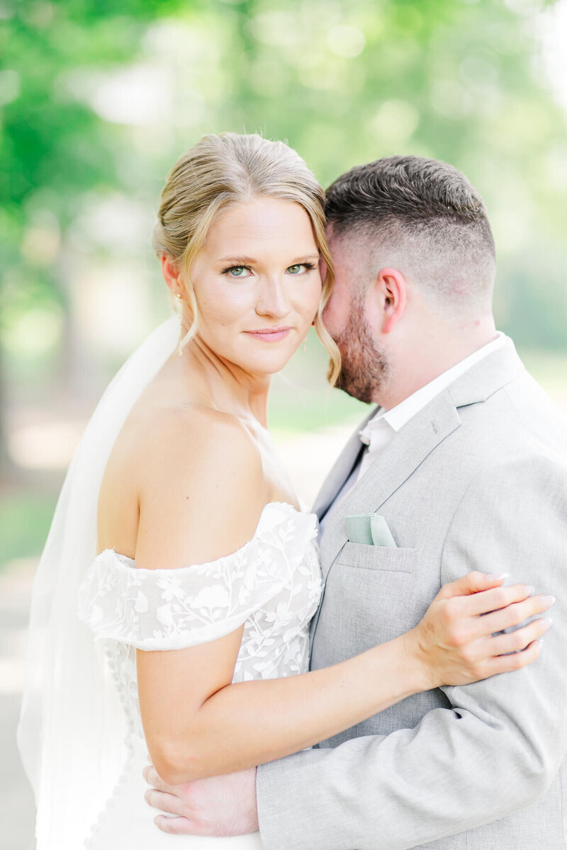 Bride and Groom embracing at summer wedding Bride and Groom dip kiss in front of Marriott Grand National | Opelika Wedding Photographer Amanda Horne