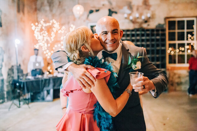 Groom getting a kiss from mom