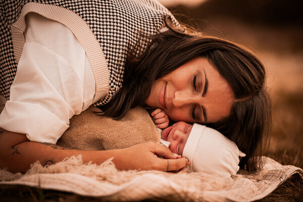 Een newborn fotoshoot in de natuur, omringt door de ouders en trouwe hond