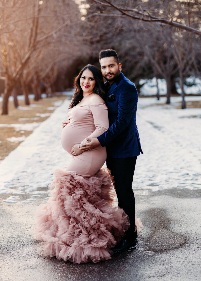 Pregnant Couple posing for photos with Belliam Photos