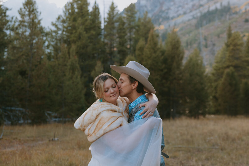 Photo of groom kidding his bride on the cheek during their Yellowstone elopement