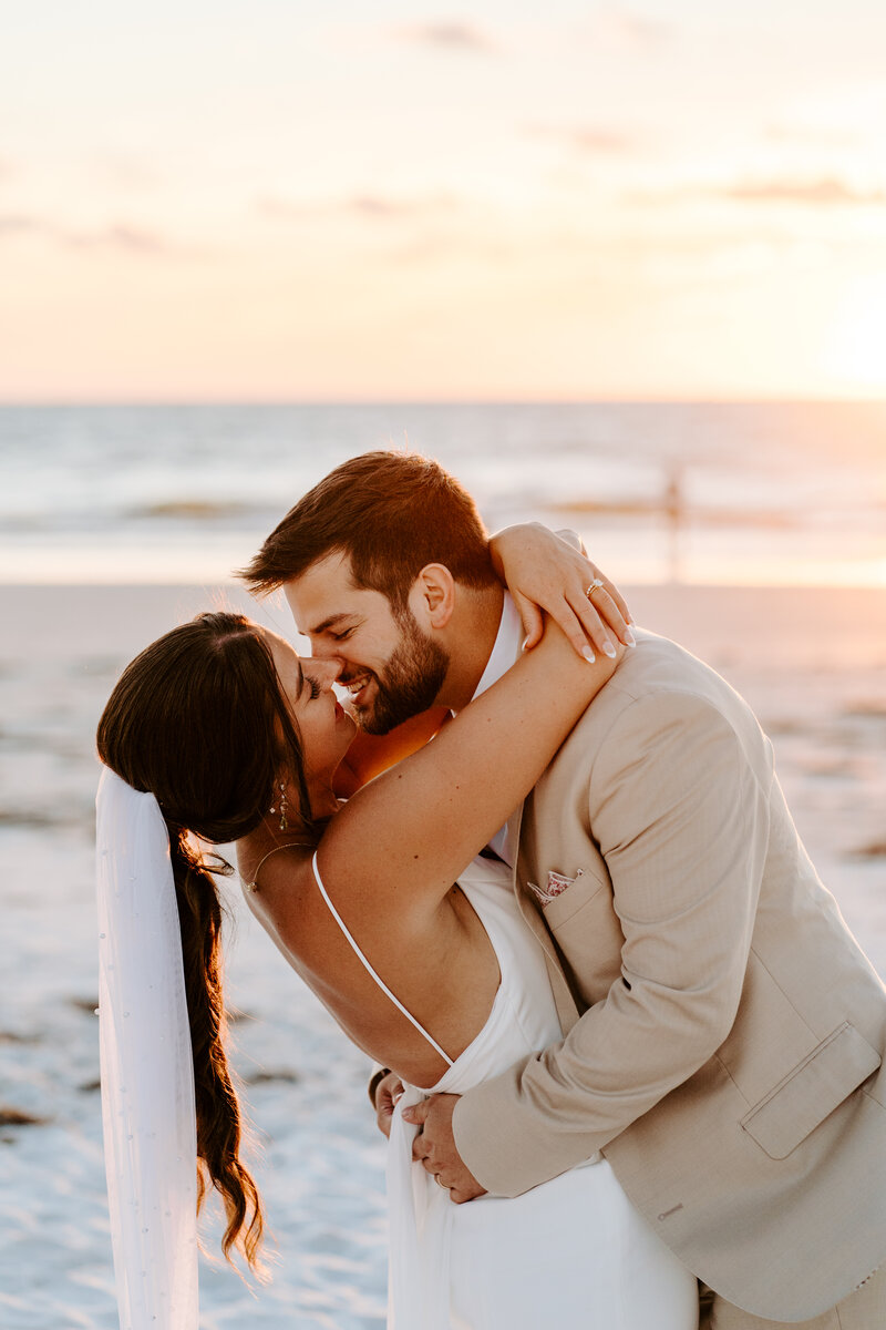 Wedding couple posing together on the beach during sunset at their destination wedding in Florida. 