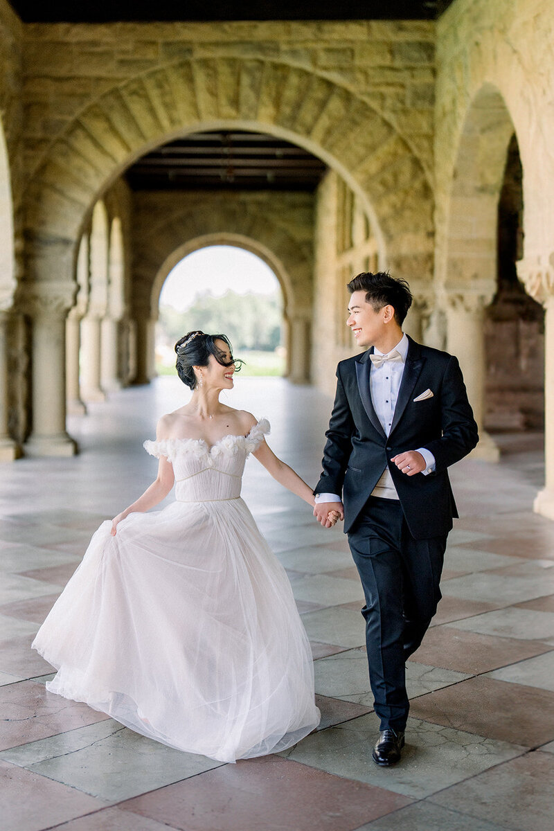 Tiffany Longeway Photography captures a joyful and elegant moment between the bride and groom at Memorial Church, Stanford University in Palo Alto, California. The historic arches and stunning architecture provide a perfect backdrop for this timeless image, ideal for couples seeking a sophisticated and iconic venue for their wedding celebration.