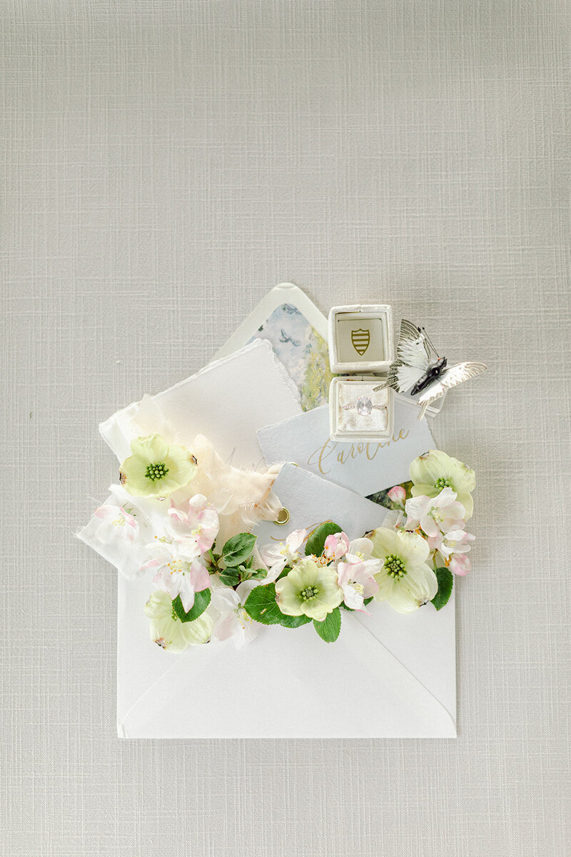 Gray linen styling mat with modern wedding invitations and minimal florals