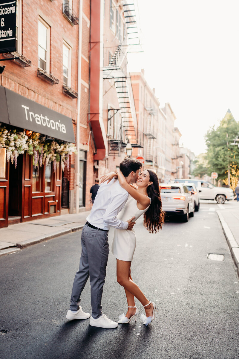 A sweet, sunlit stroll through the North End—this couple’s love shines as they walk hand in hand down the historic streets of Boston, sharing a quiet moment of happiness.