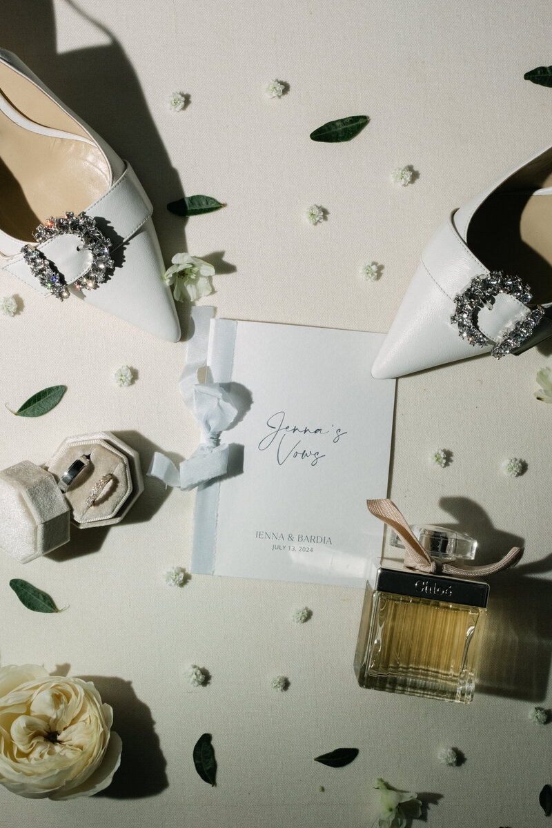 Luxury Wedding Flat lay of brides details including vows, rings, jimmy choo heels and Chloe perfume 