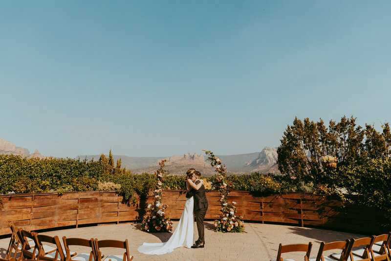 couple kissing in front of red rocks in sedona