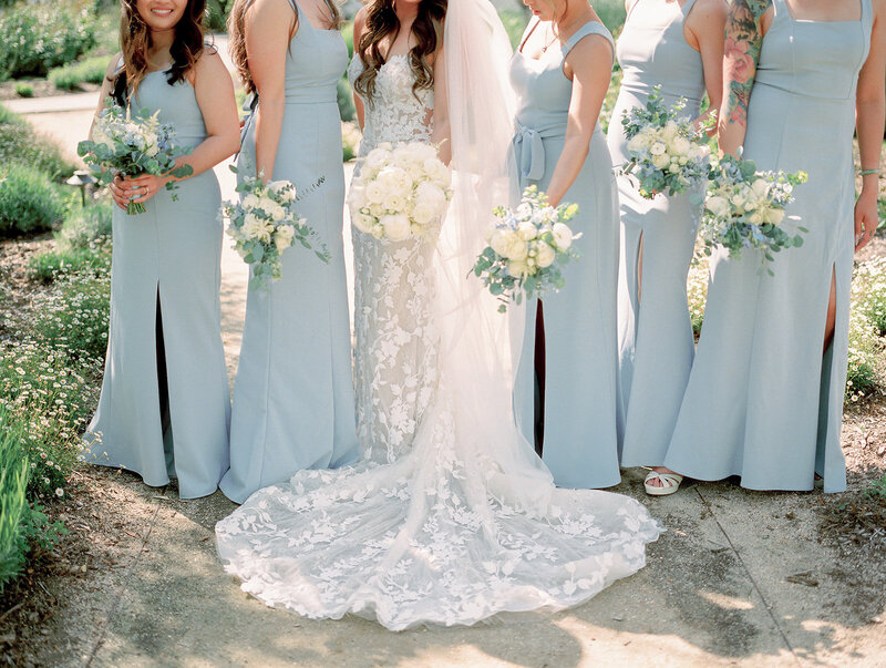 Bride and bridesmaids in blue dresses posing for a photo.