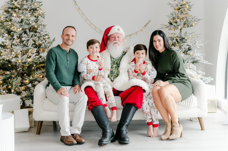 Brother and sister sitting on Santa's lap reading The Night Before Christmas at an Atlanta Santa experience in Milton, GA Studio