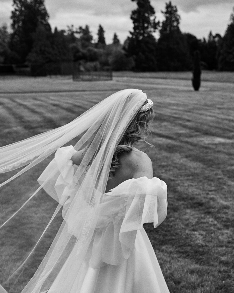 bride in dress with veil blowing in the wind