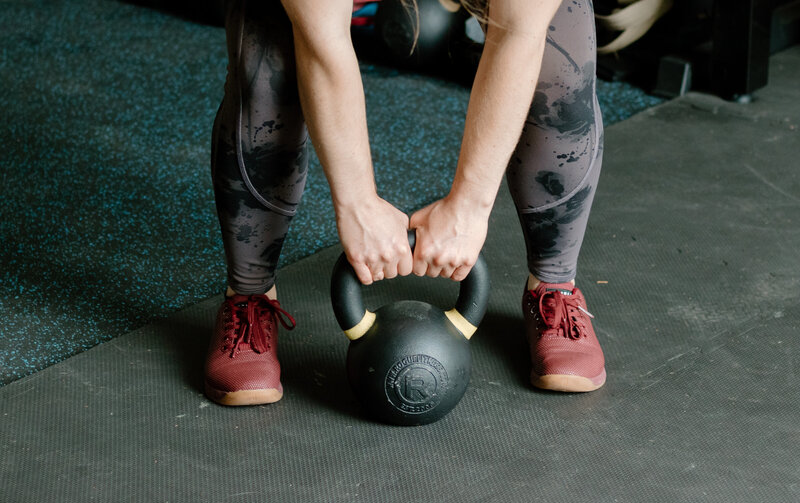 woman holding dumbbell while squatting