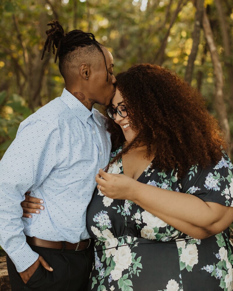 man kisses woman's forehead