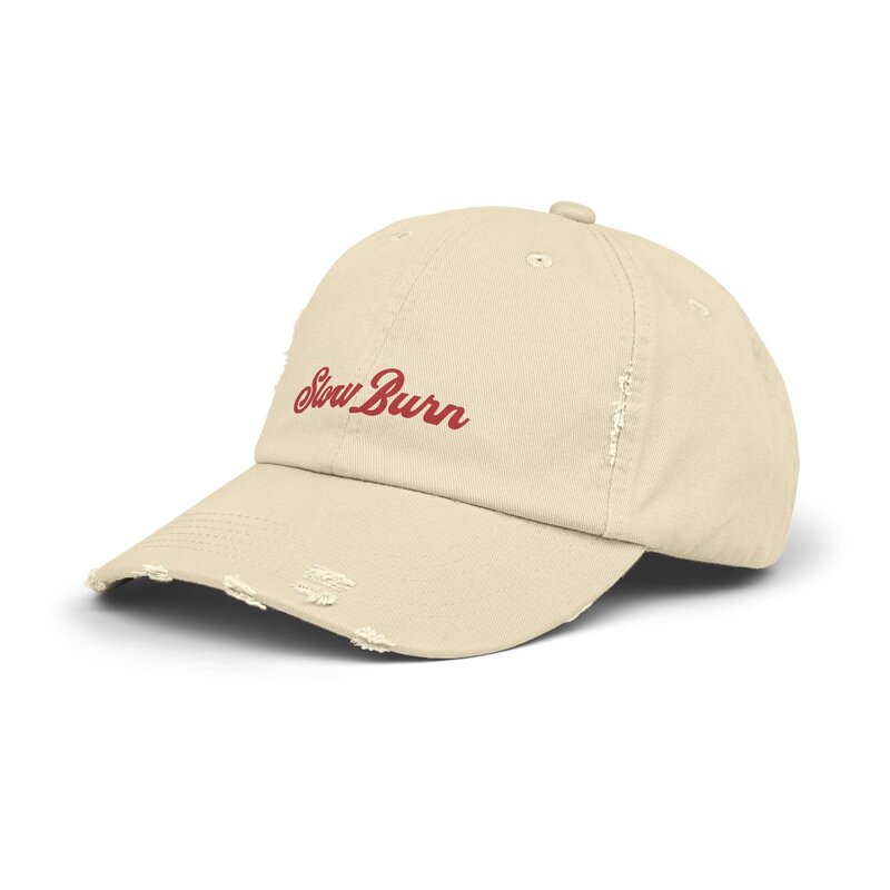 A cream and red distressed hat that says slow burn.