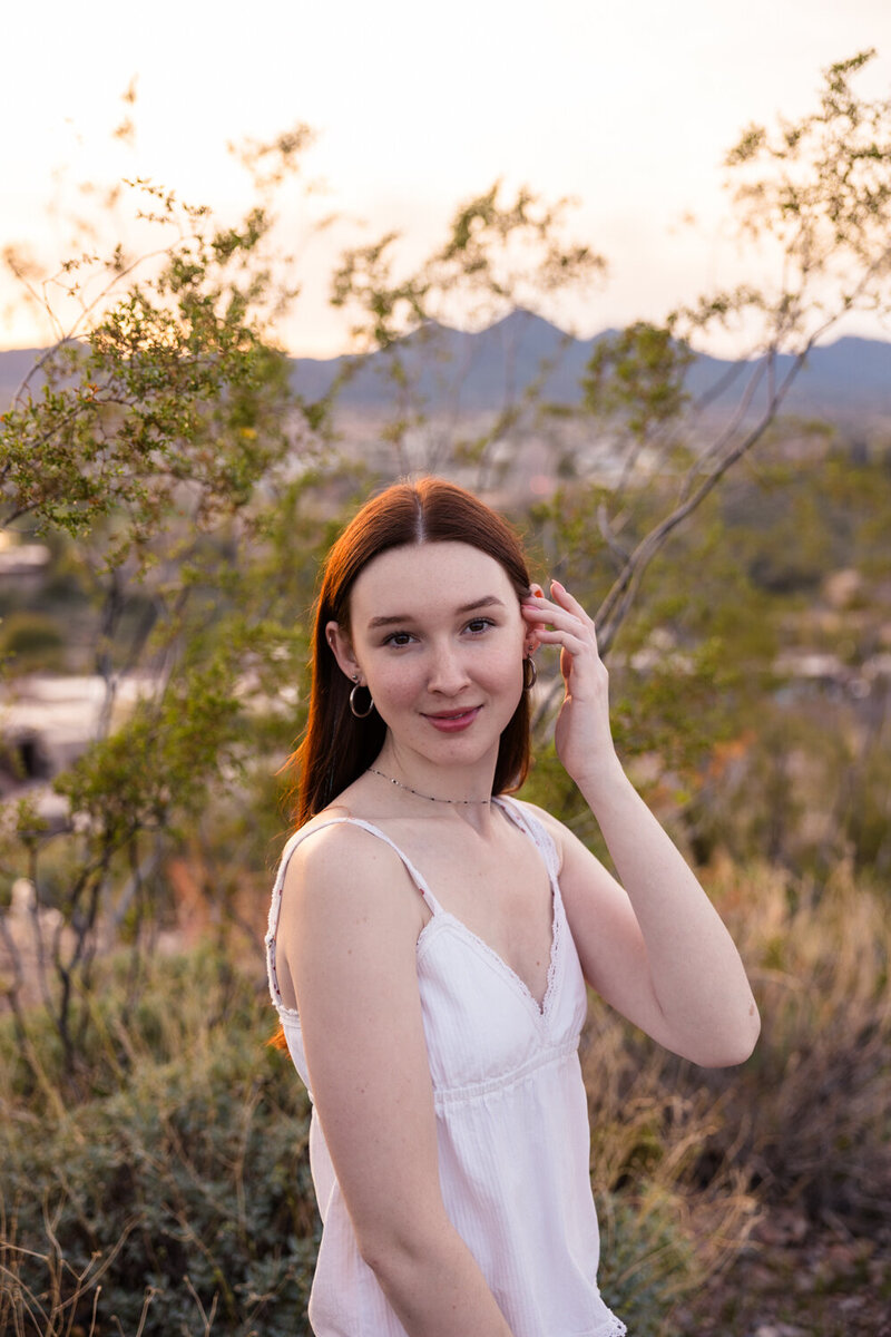high school senior tucking hair behind her ear