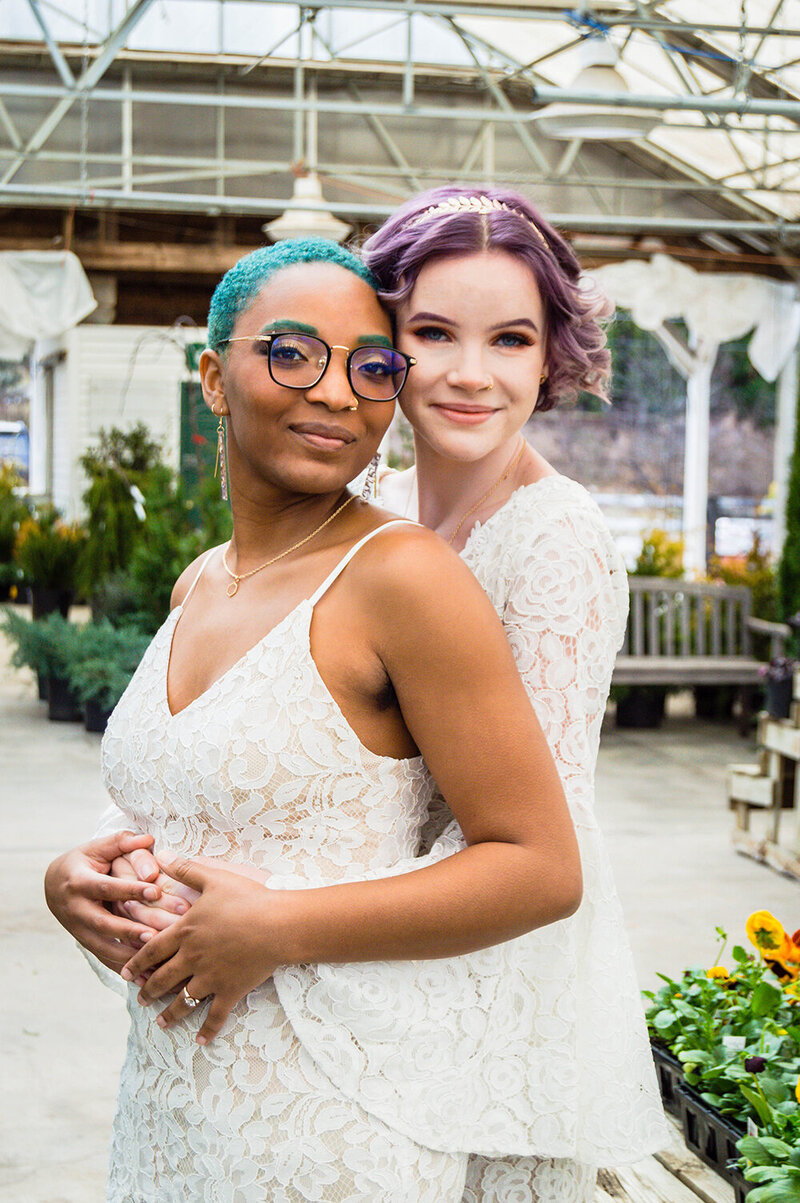 An LBGTQ+ couple embraces one another in a greenhouse in Roanoke, Virginia on their elopement day.