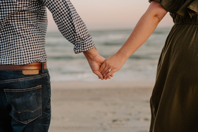 Couple holds hands on the beach