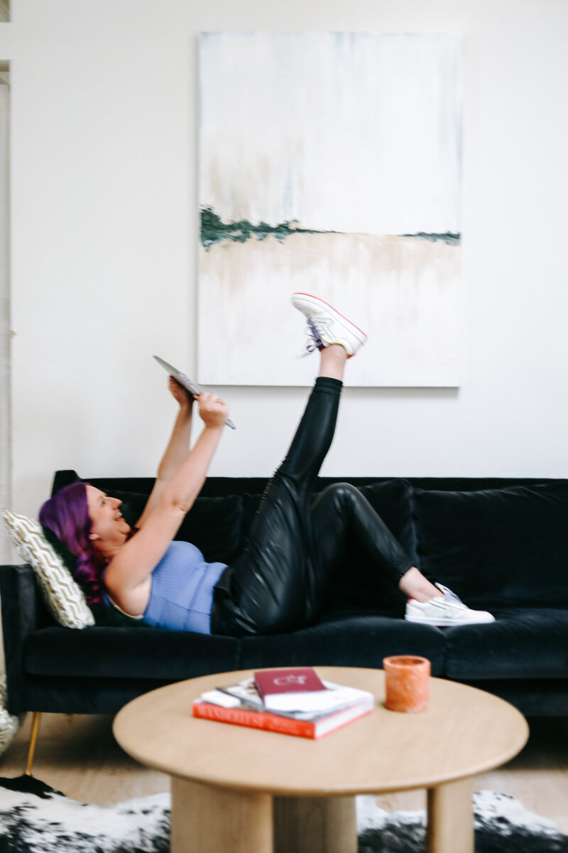 Podcast | Mindset & Mastery For Photographers With Karinda K | How to Grow Your Photography Business | Karinda on a couch reading a book