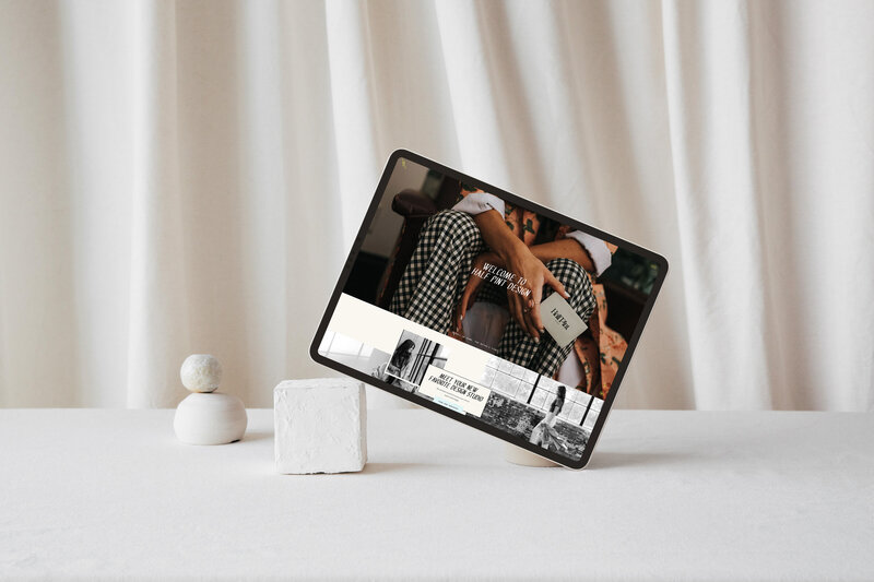 A tablet displaying a fashion image with a model holding a book, positioned on a minimalistic stand with white geometric objects on a white surface and backdrop, exemplifying our brand identity services.