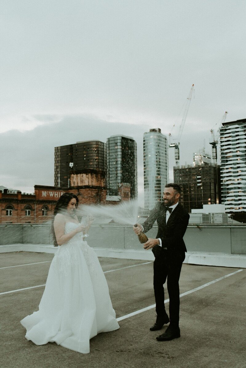 Bride and Groom at McWhirters Carpark spraying champagne