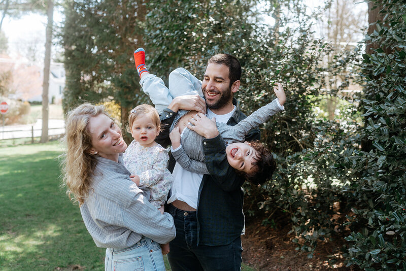 couple smiling and holding their kids during family photos captured by NYC family photographer Elsie Goodman 