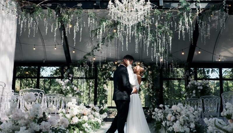 A newlywed couple with their arms around each other dancing 