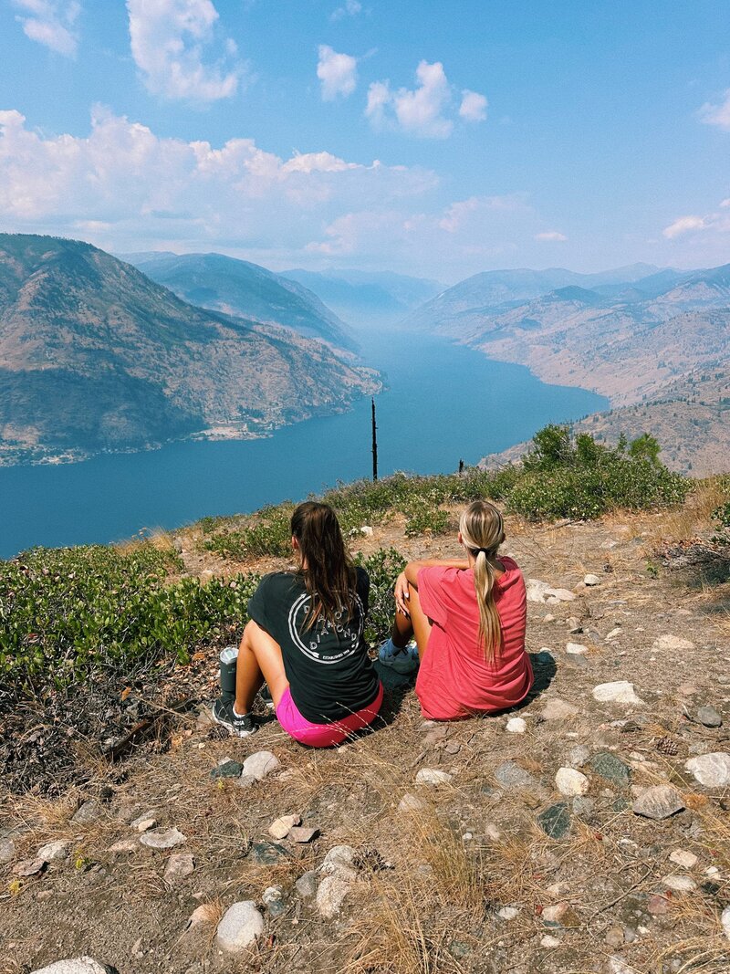 Friends looking out on a river at the end of a hike.