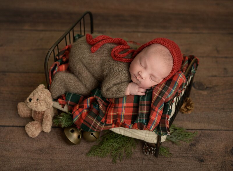 baby sleeping on a tiny bed and decorated for holidays