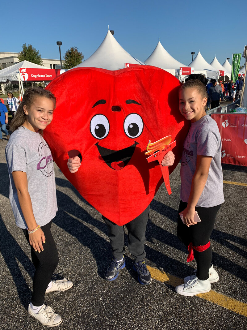 DJ and guests posing with a heart mascot at a themed corporate event in Chicago