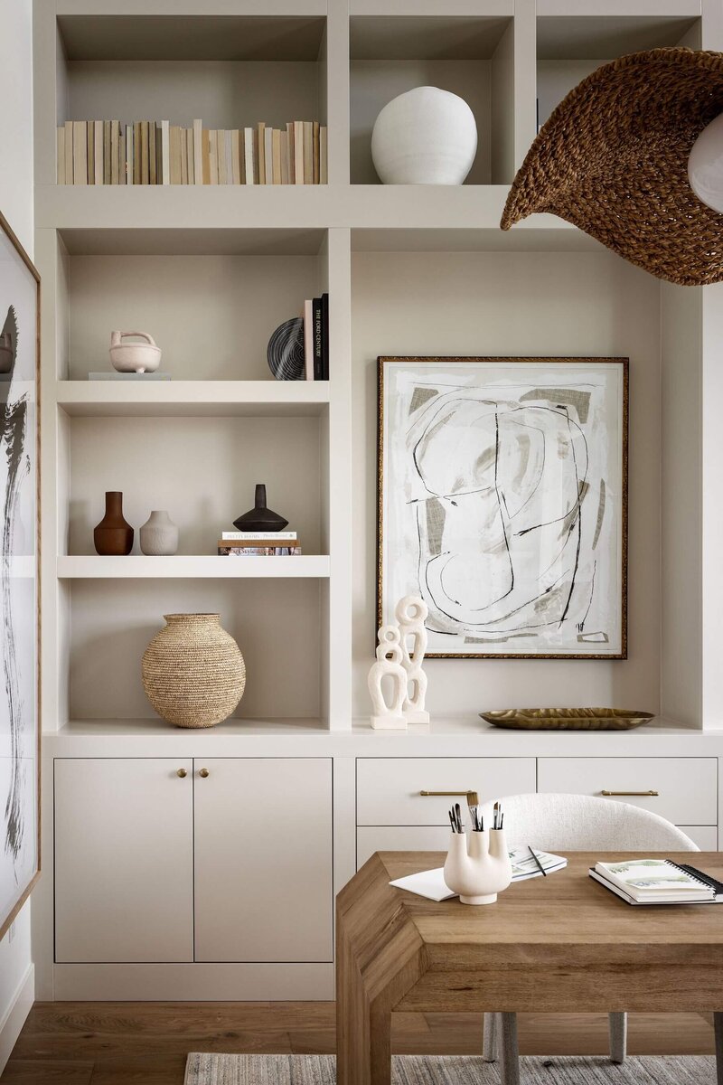 Beautiful natural cream builtins with thoughtful accessories, oversized rattan light fixture and wooden desk. 