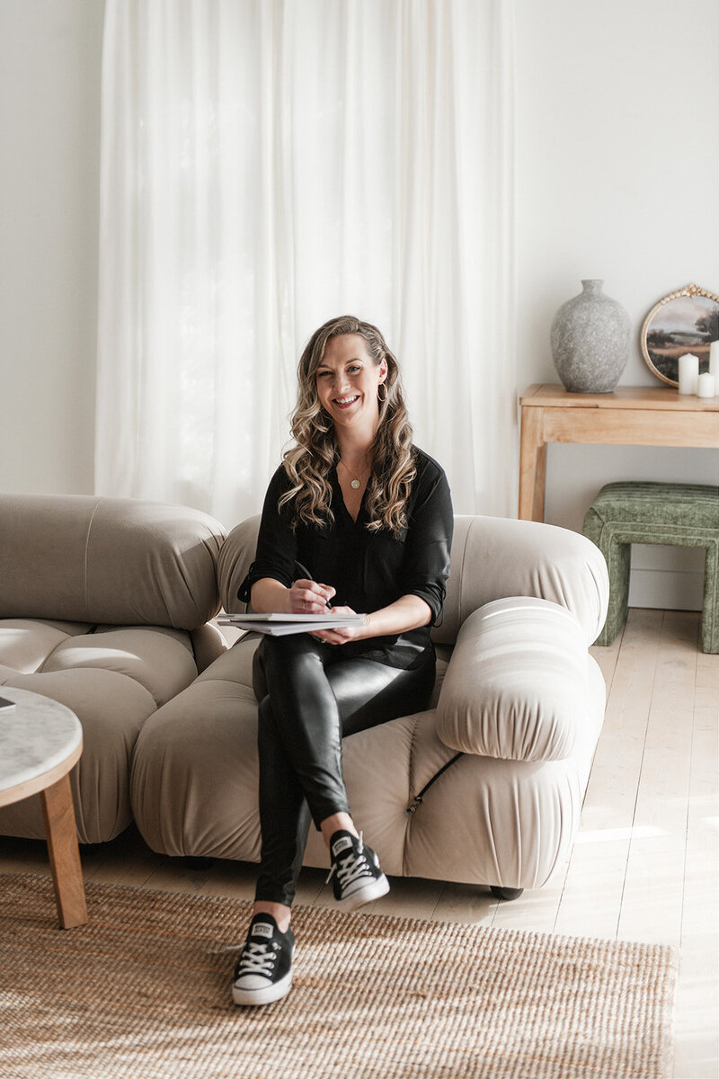 erika-owner-of-creatively-social-co-sitting-down-with-a-notebook-and-smiling