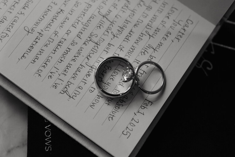 Wedding rings laying on notebook with handwritten vows