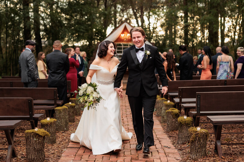 Couple walking down outdoor aisle after wedding ceremony