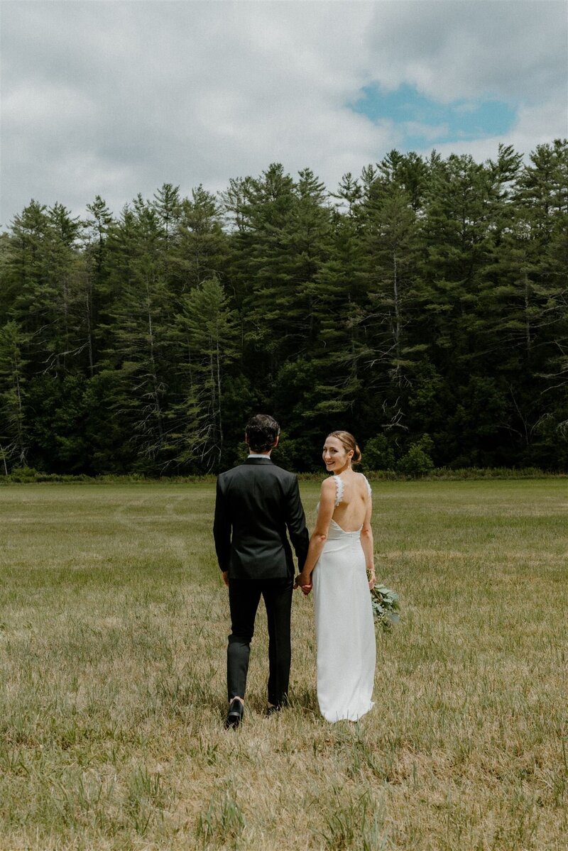 couple walking in field during wedding day