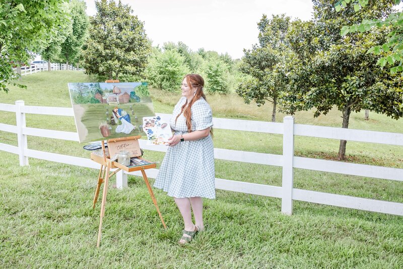 Elyse Stokes working on an Atlanta Live Wedding Painting at an outdoor ceremony, capturing the bride and groom's kiss at the end of the aisle