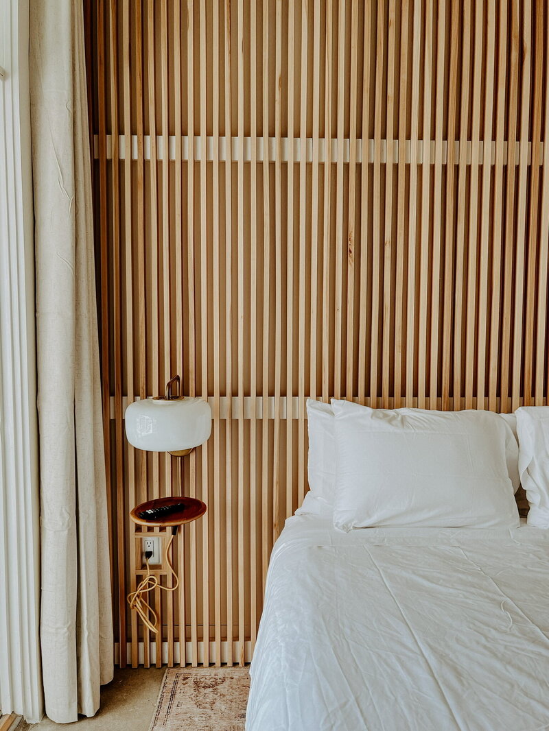 white bed against wood accent wall