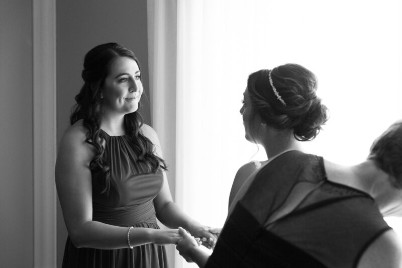 maid of honor holding bride's hands